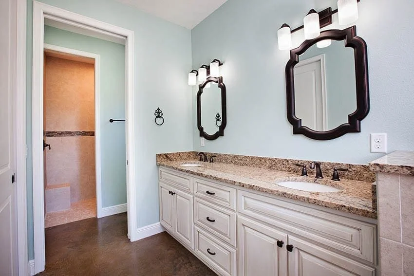 Bathroom double vanity with white cabinets, granite top and framed mirrors