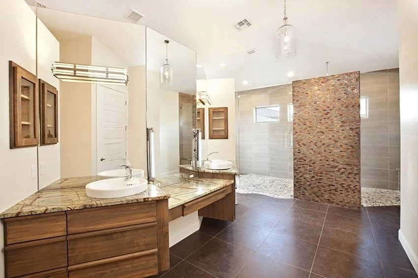 Bathroom with a floating walnut vanity, two vessel sinks, a granite top and a walk-in shower with a mosaic tile wall