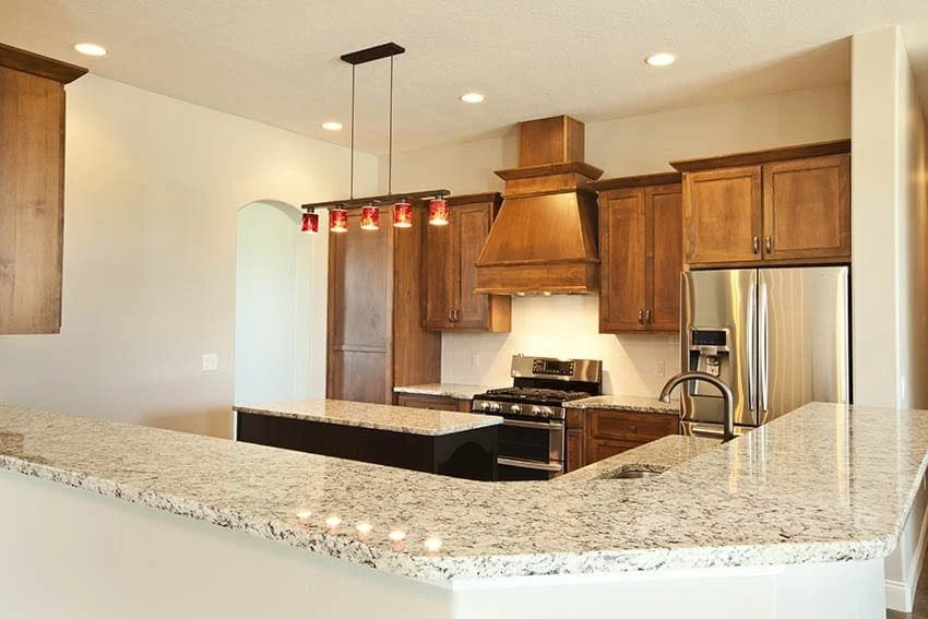 Kitchen with stained wood cabinets, granite countertops and a custom range hood
